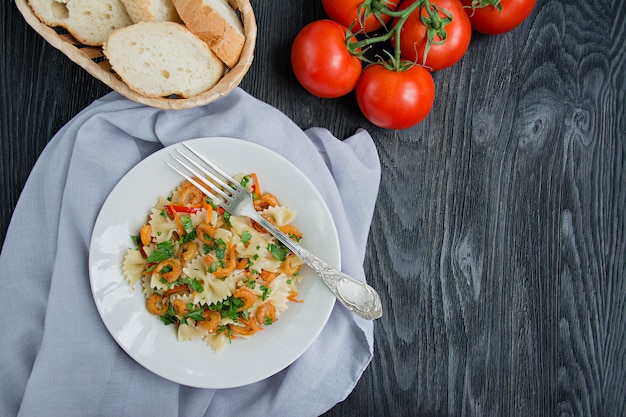 Итальянская паста в соусе с креветками на тарелку, вид сверху.