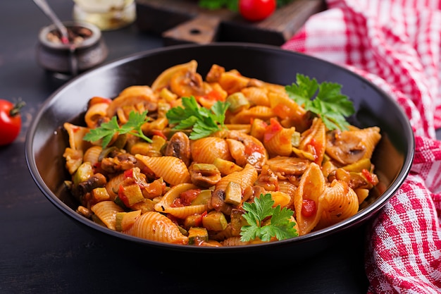 Italian pasta shells with mushrooms, zucchini and tomato sauce