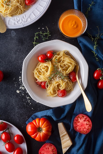 Italian pasta spaghetti with fried cherry tomato and thyme, top view