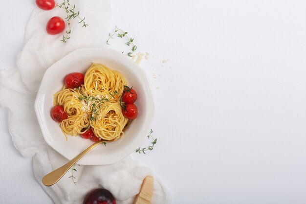 Italian pasta spaghetti with fried cherry tomato and thyme, top view