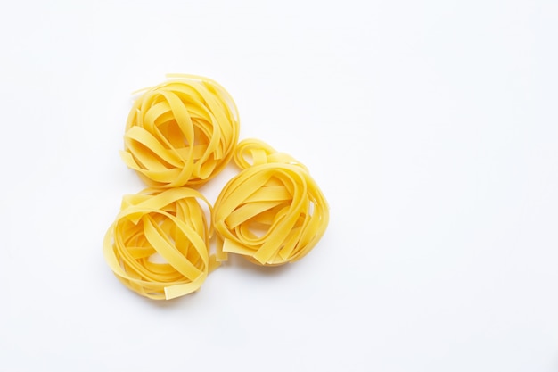 Italian pasta tagliatelle nest on white