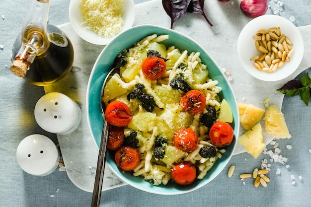 Italian pasta trofie with potato fried cherry tomatoes and basil pesto healthy traditional cuisine