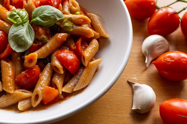 Pasta italiana con pomodoro e olive vista ad alto angolo di frutta in contenitore su tavola