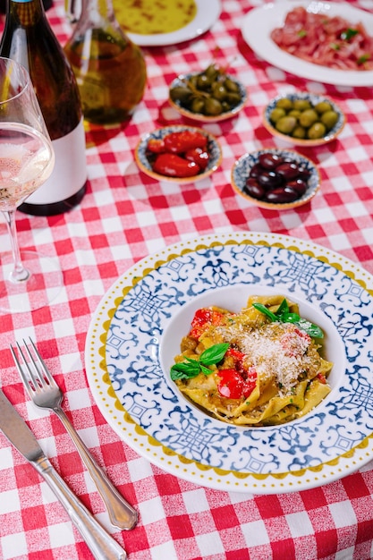 Foto pasta italiana con pomodori, parmigiano, basilico e vino bianco