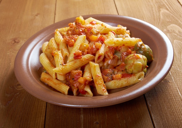Italian Penne rigate pasta  with  vegetable  tomato sauce  on wooden table