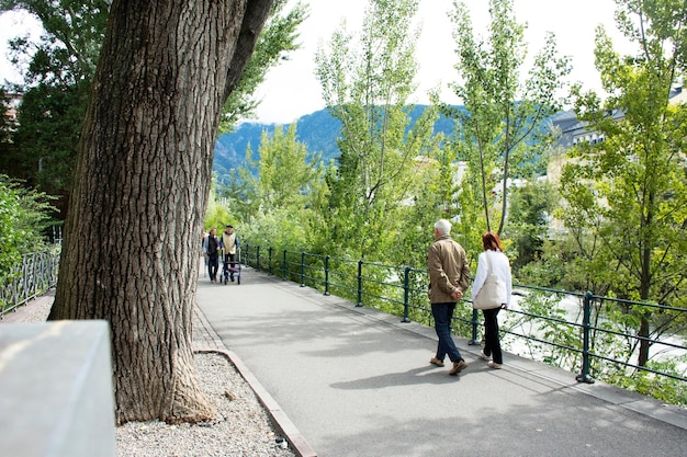 Italian people and foreigner travelers walking relax on footpath at riverside of passer river go to Christmas Market in Meran city on September 2 2017 in Merano Italy