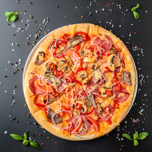 Italian pizza on a dark background, top view