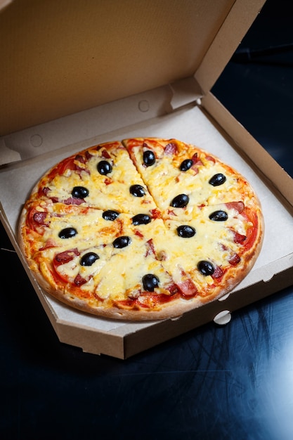 Italian pizza delivery. Delicious oven baked pizzeria dish with, mozzarella, parmesan and cheese, delivered in a cardboard box. Delicious takeaway fast food cooked in the oven for dinner.