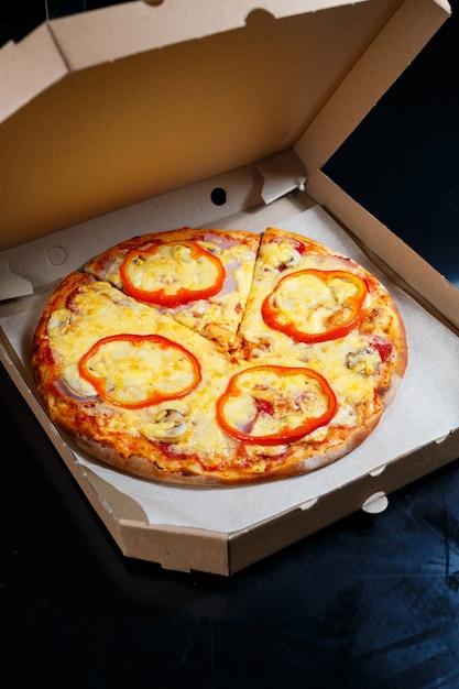 Italian pizza delivery. delicious oven baked pizzeria dish\
with, mozzarella, parmesan and cheese, delivered in a cardboard\
box. delicious takeaway fast food cooked in the oven for\
dinner.