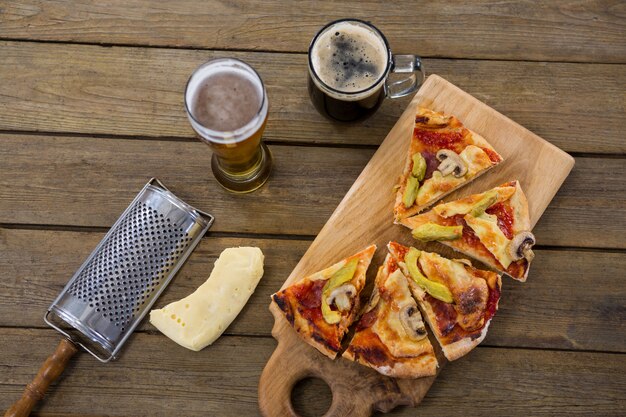 Italian pizza served on a chopping board with a beer mug and glass