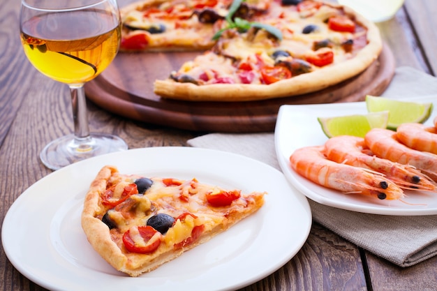 Italian pizza and shrimps on wooden table