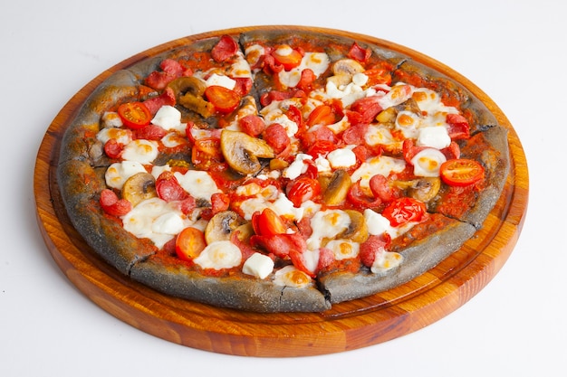 Photo italian pizza with black dough on wooden board