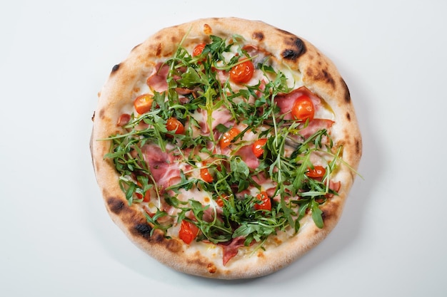 Italian pizza with ham arugula and tomatoes