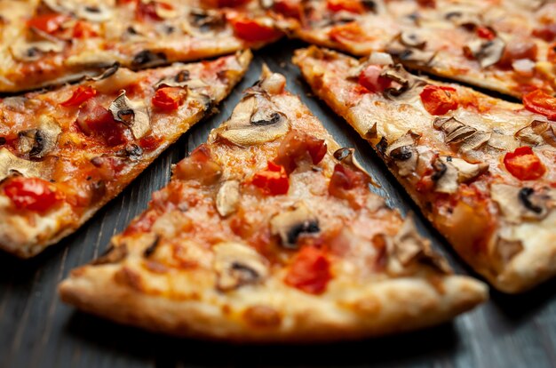 italian pizza with mushrooms, tomatoes and cheese on wood