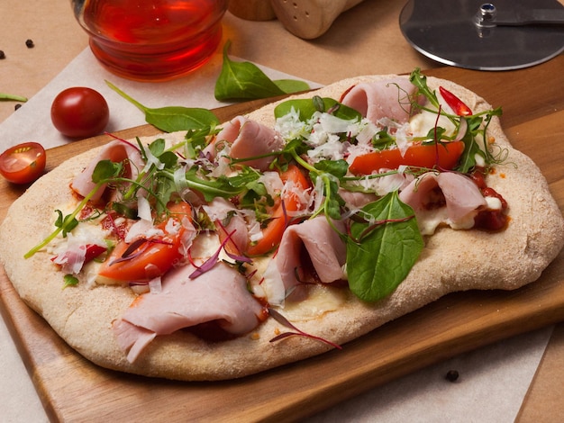 Italian pizza with Parma ham on a wooden board in the restaurant