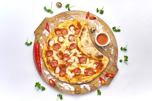 Italian pizza with pepperoni, mozzarella and tomato sauce wooden table with chilli pepper background