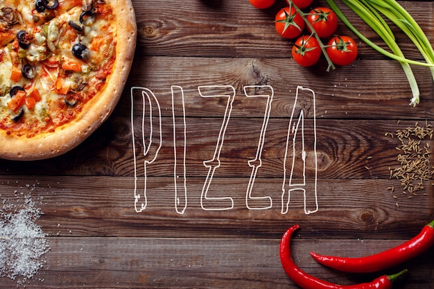 Italian pizza with tomatoes on a wooden table, top view, close-up. Pizza text on center.