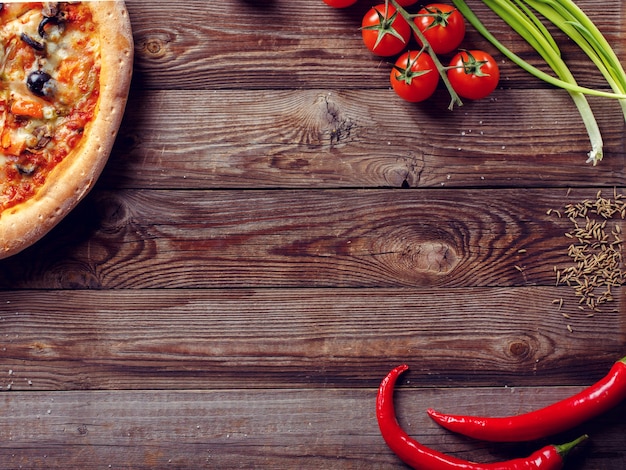 Italian pizza with tomatoes on a wooden table top view