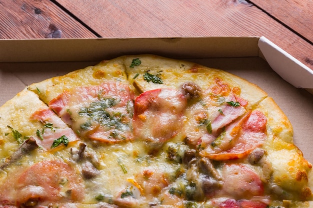 Foto pizza italiana su tavole di legno pizza con pancetta pomodori secchi e funghi cucina italiana close up