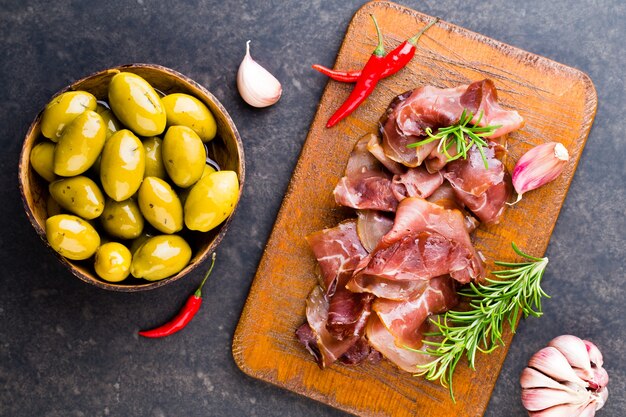 Italian prosciutto crudo or jamon with spice, olive, rosemary