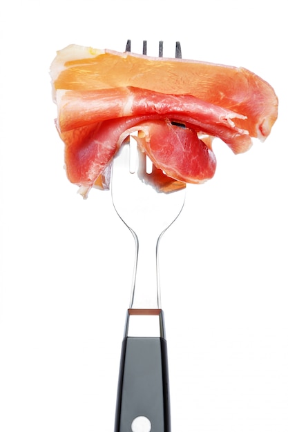 Italian prosciutto crudo or spanish ham on fork