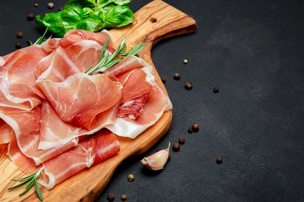 Italian prosciutto crudo or spanish ham. Raw ham on wooden cutting board