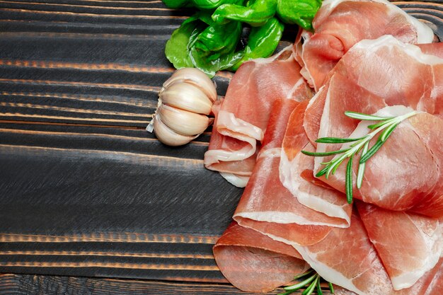 Italian prosciutto crudo or spanish ham. Raw ham on wooden surface