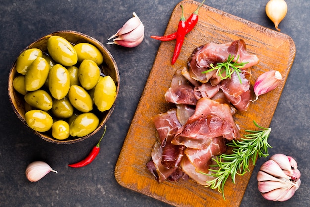 Prosciutto crudo italiano con spezie e olive