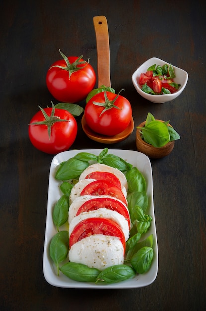 Photo italian salad  antipasto called caprese with buffalo mozzarella, tomato and basil with olive oil