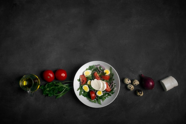 Italian salad prepared with arugula, mozzarella, eggs. Black background