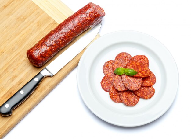 Italian Salami or spanish chorizo on plate white isolated