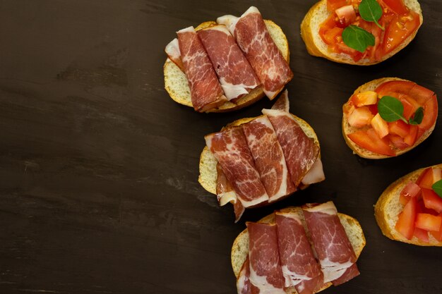 Italian snack bruschetta, with tomatoes and smoked meats