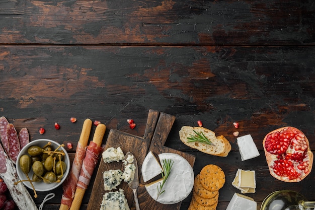 Italian snacks, meat cheese, herbs set, on dark wooden, flat\
lay