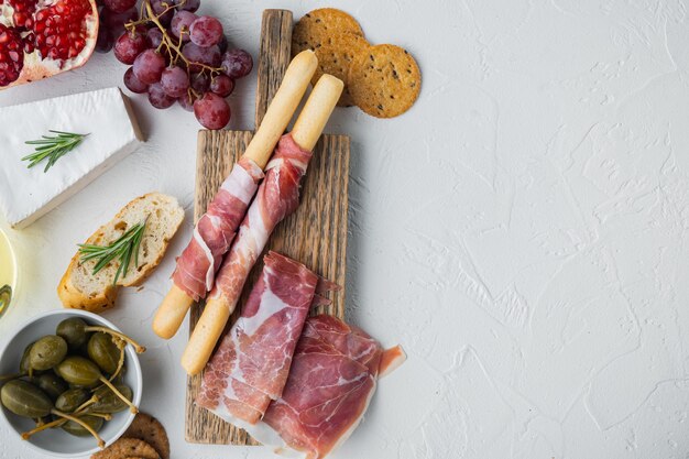 Italian snacks, meat cheese, herbs set, on white background, flat lay  with copy space for text