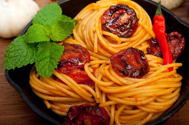 Italian spaghetti pasta and tomato with mint leaves