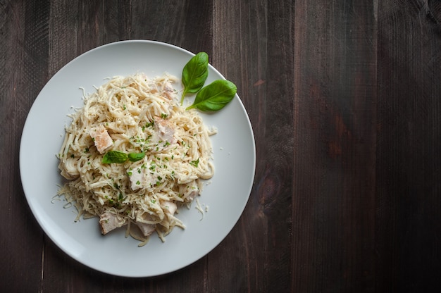 Italian spaghetti pasta with sauce and chicken, cheese parmesan and basil,y