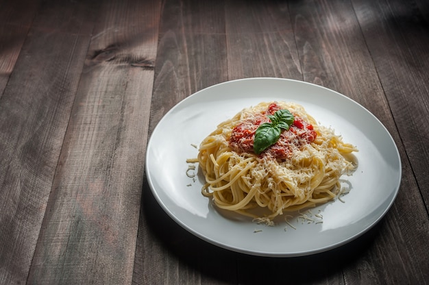 Итальянская паста спагетти с соусом и курицей, сыром пармезан и базиликом