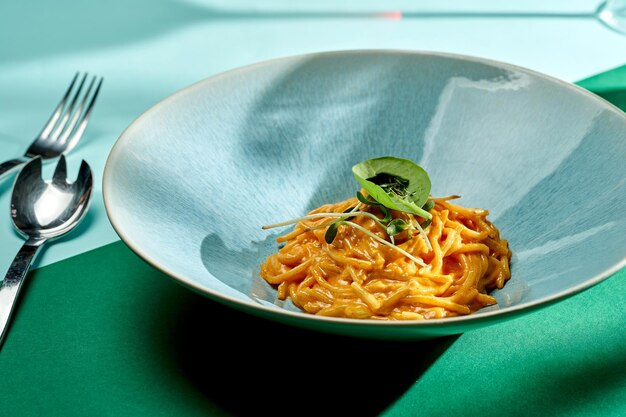 Italian spaghetti pasta with tomato and cheese sauce in a plate with bright backgrounds. Selective focus, hard shadows