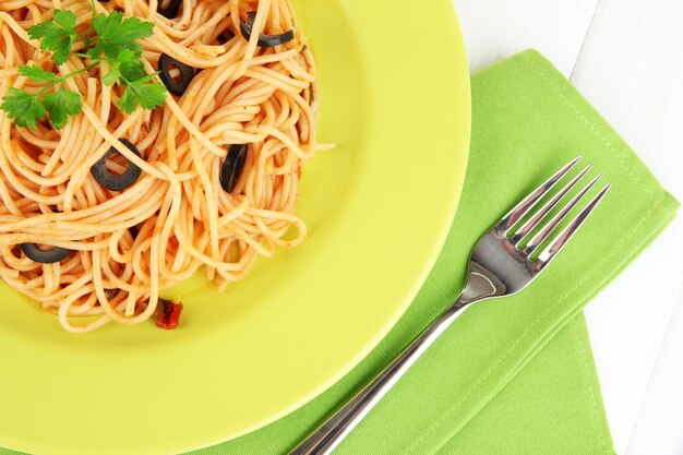 Italian spaghetti in plate on wooden table closeup