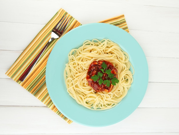 Foto spaghetti italiani in piatto sulla tavola di legno
