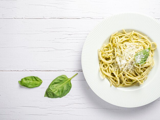 Italian spaghetti with fresh homemade pesto sauce Eaten on a white wooden board