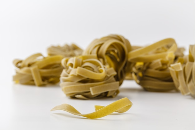 Italian spinach tagliatelle nests on white