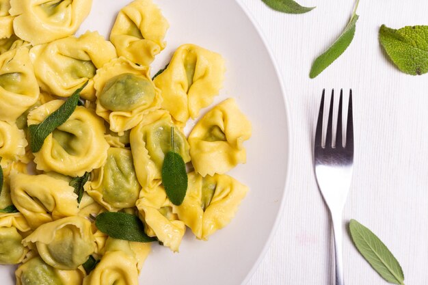写真 リコッタとスパナッチでめ込まれたイタリアのラビオリプレートで提供される新鮮な食事のクローズアップ