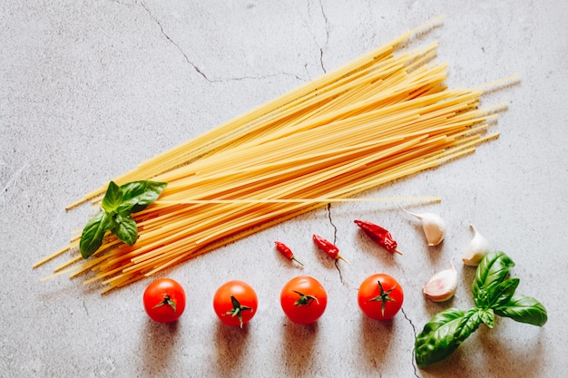 Italian style flat lay with tomatoes, garlic and spaghetti
