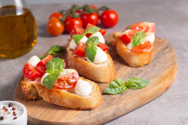 Italian tomato and cheese bruschetta Tapas antipasti with chopped vegetables herbs and oil on grilled ciabatta and baguette bread