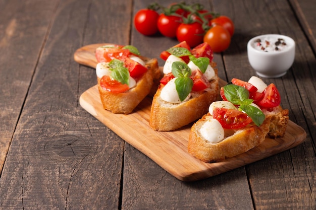 Italian tomato and cheese bruschetta Tapas antipasti with chopped vegetables herbs and oil