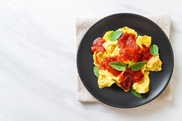 Pasta italiana dei tortellini con salsa di pomodoro - stile alimentare italiano