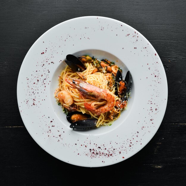 Italian traditional pasta with seafood. Shrimps, mussels, squid. Top view. Free copy space.