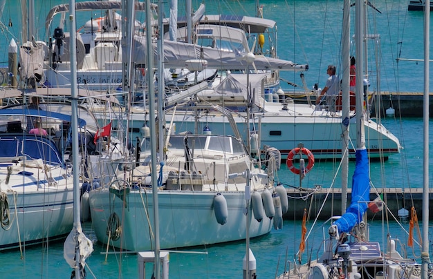 Italië, Sicilië, Middellandse Zee, Marina di Ragusa (provincie Ragusa); 17 juni 2023, echtpaar op een zeilboot in de haven - EDITORIAL