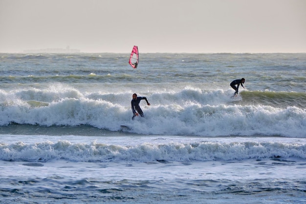 Italië, Sicilië, Middellandse Zee, Marina di Ragusa (provincie Ragusa); 7 december 2021, windsurfers in zee - REDACTIONEEL